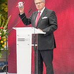Były Prezydent Polski Bronisław Komorowski przemawia z mównicy, prezentując kubek po babci Sybiraczce