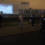 Na budynku Muzeum Pamięci Sybiru wyświetla się iluminacja, ludzie stojący na chodniku nagrywają telefonami pokaz