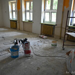 Prace remontowe w szkole, na podłodze leży worek betonu oraz mieszadło