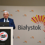 Prezydent Tadeusz Truskolaski zabiera głos podczas spotkania, w tle baner: Nie śpij, bo Cię przegłosują