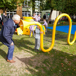 Prezydent Tadeusz Truskolaski przemawia do dziecka przez trąbkę znajdującą się na placu zabaw 