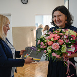 Uśmiechnięta kobieta prezentuje otrzymany bukiet kwiatów 