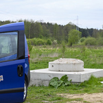 Tereny zielone, fragment infrastruktury sanitarnej .Obok stoi samochód Wodociągów Białostockich, w tle las              h 