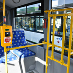 wnętrze autobusu, niebieskie fotele, kasownik.