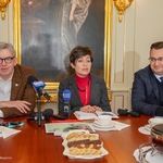 Osoby siedzące przy stole na konferencji prasowej
