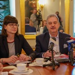 Dyr. Mirończuk i dyr. Karolski siedzą przy stole . Na stole stoją mikrofony  