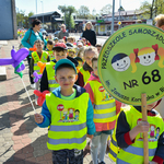 Przedszkolaki podczas spaceru z tablicą Przedszkole Samorządowe Nr 68