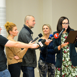 Dziennikarze z mikrofonami nagrywają rzecznika prasowego