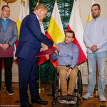 Prezydent wręcza nagrodę osobie na wózku inwalidzkim