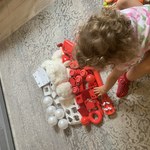 Dziecko bawi się biało-czerwonymi klockami