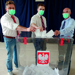 Trzej mężczyźni wrzucają swoje głosy do urny wyborczej