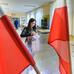 Mieszkanka wrzuca głos do urny wyborczej