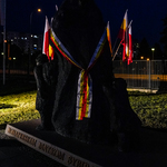 Pomnik Bohaterskim Matkom Sybiraczkom w Białymstoku owinięty wstęgą oraz narodowe flagi Polski.