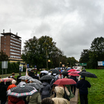 Tłum wiernych, idących podczas procesji z parasolami