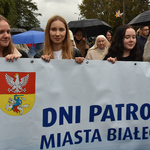 Młodzi ludzie trzymający transparent z napisem Dni Patronalne Białegostoku i herbem Białegostoku