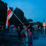 Rodzina podczas koncertu z biało-czerwono-białą flagą Białorusi