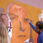 Uczennice malują mural na budynku szkoły