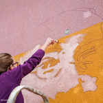 Uczennica maluje mural na budynku szkoły