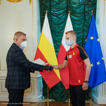 Prezydent Tadeusz Truskolaski wręczający wyróżnienie i podziękowania piłkarzowi Krystianowi Furmanowi