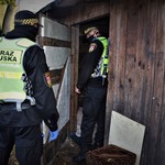 Strażnicy miejscy wchodzą do drewnianego, opuszczonego domu