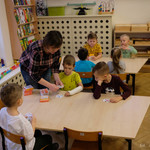 Przedszkolanka przy ławce uczy dzieci reguł gry 
