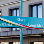 Tablica z nazwą skweru przewiązana wstęgą w barwach Białegostoku