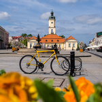 Żółty rower na tle Ratusza w Białymstoku
