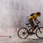 Rowerzysta na rowerze pod strumieniem kurtyny wodnej
