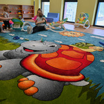Motyw kolorowego żółwia na dywanie w sali zabaw
