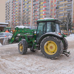 Traktor odśnieżający drogę na osiedlu