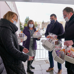 Przedstawiciele Urzędu Miejskiego wręczający koszyki ze słodyczami pracownicom szpitala
