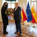 Prezydent Tadeusz Truskolaski wręczający wyróżnienie i kwiaty dyrektor Monice Szewczyk