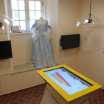 Wnętrze Multimedialnego Centrum Informacji Turystycznej z multimedialnym stołem i dekoracyjną suknią