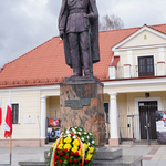 Kwiaty pod pomnikiem Marszałka Józefa Piłsudskiego w otoczeniu biało-czerwonych flag