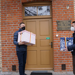 Zastępcy prezydenta Rafał Rudnicki i Przemysław Tuchliński trzymający prezenty przed wejściem do placówki opiekuńczo-wychowawczej