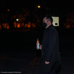 Zastępca prezydenta Przemysław Tuchliński trzymający w ręku zapalony znicz