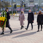 Przedstawiciele Rady Miasta niosący wieniec przed tablicę upamiętniającą ofiary katastrofy smoleńskiej