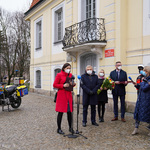 Uczestnicy konferencji przed Pałacykiem Gościnnym, w tle: motocykl ratunkowy