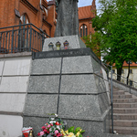 Pomnik Papieża Jana Pawła II przyozdobiony kwiatami i zniczami