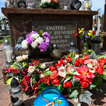 Pomnik-kwatera poległych żołnierzy udekorowana kwiatami i zniczami
