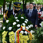 Strażnik miejski i zastępca prezydenta Przemysław Tuchliński składają kwiaty pod pomnikiem