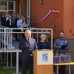 Prezydent Tadeusz Truskolaski przemawia do gości, w drugim rzędzie stoi pani dyrektor z nauczycielem, w tle widać dzieci uczestniczące w apelu