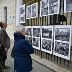 Przechodnie oglądający wystawę na ogrodzeniu siedziby Galerii im. Sleńdzińskich