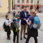 Zastępca prezydenta Rafał Rudnicki wręcza bilety dzieciom na Rynku Kościuszki