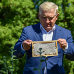 Prezydent Tadeusz Truskolaski trzyma ramkę z miodem