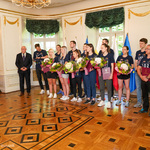 Po lewej stronie do mikrofonu przemawia prezes Zarządu Polskiego Związku Badmintona, po prawej stronie stoją zawodnicy UKS Hubal Białystok wraz z Zastępcą Prezydenta