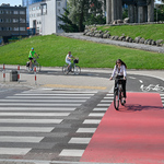 Rowerzyści jadący ścieżką rowerową od strony Parku Centralnego, w tle widoczny fragment Pomnika Bohaterów Ziemi Białostockiej