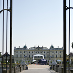 Widok na rozstawione studio plenerowe TVN w Ogrodach Branickich przez bramę, w tle widać Pałac