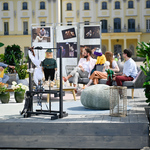 Prowadzący program rozmawiają w studiu plenerowym z aktorami Białostockiego Teatru Lalek, na scenie jest ustawiony wieszak na którym prezentowane są lalki teatru
