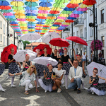 Grupa taneczna dziewcząt wraz z Dorotą Gardias pozuje pod kolorowymi parasolkami na ulicy Kilińskiego